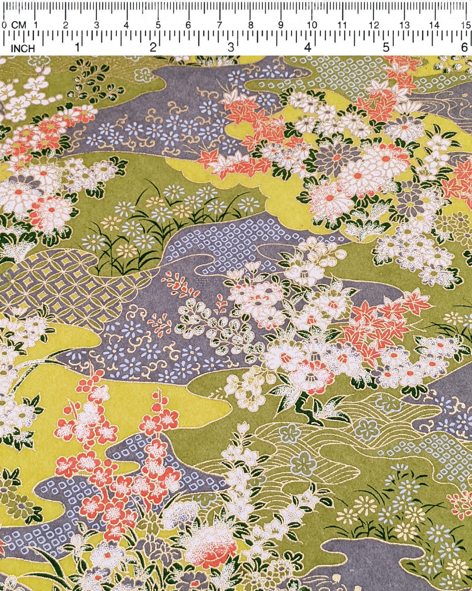 Japanese chiyogami paper featuring small white, green, and orange flowers on a gray and green background embedded with various traditional Japanese motifs with metallic gold details.