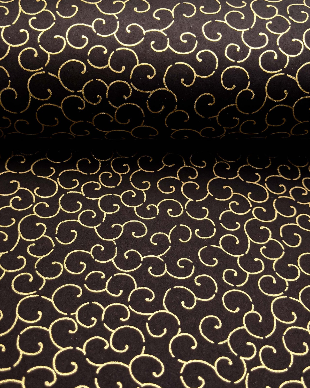 Japanese chiyogami paper featuring a metallic gold traditional karakusa design on a black background.