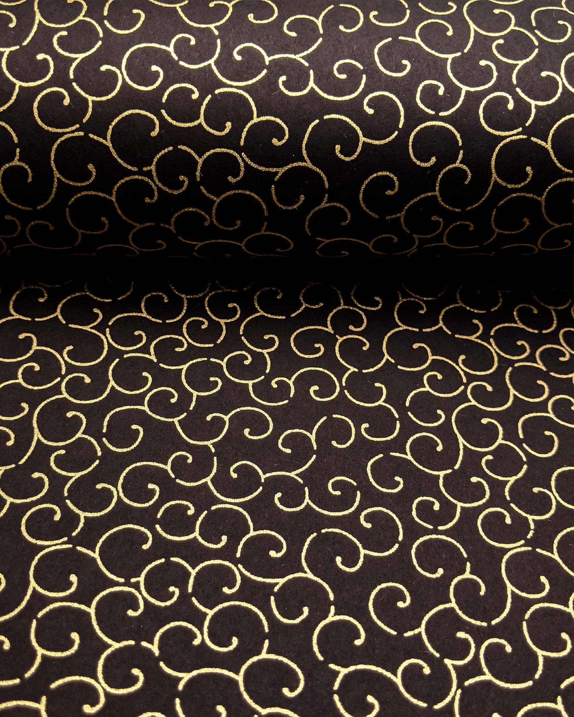 Japanese chiyogami paper featuring a metallic gold traditional karakusa design on a black background.