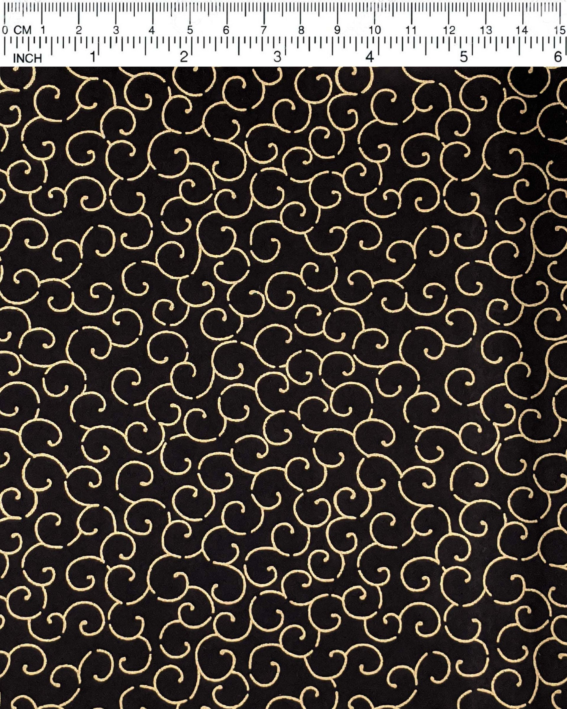 Japanese chiyogami paper featuring a metallic gold traditional karakusa design on a black background.