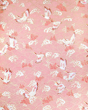 Japanese chiyogami paper featuring white and pink cranes flying over a pink wave background with metallic gold details.