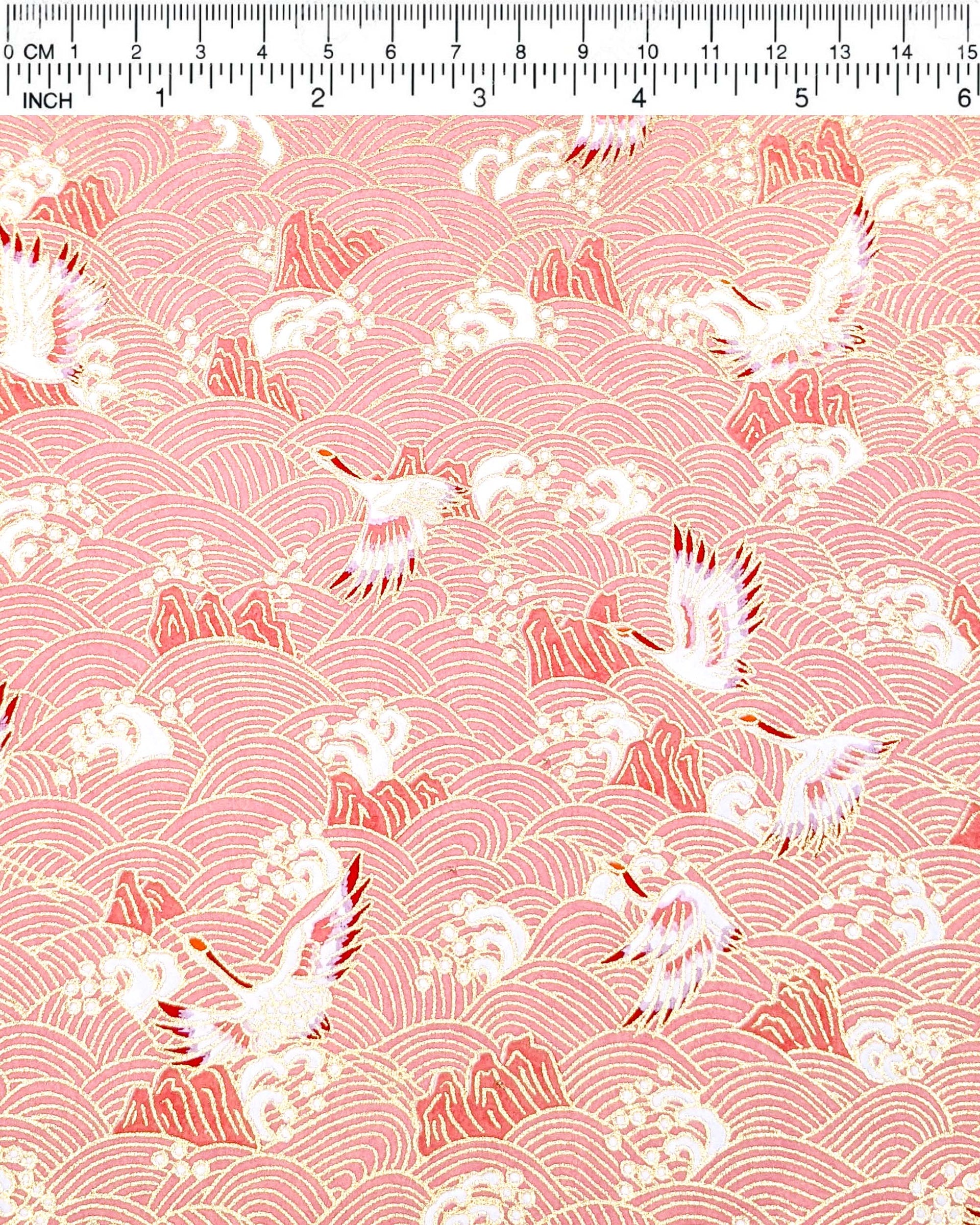 Japanese chiyogami paper featuring white and pink cranes flying over a pink wave background with metallic gold details.