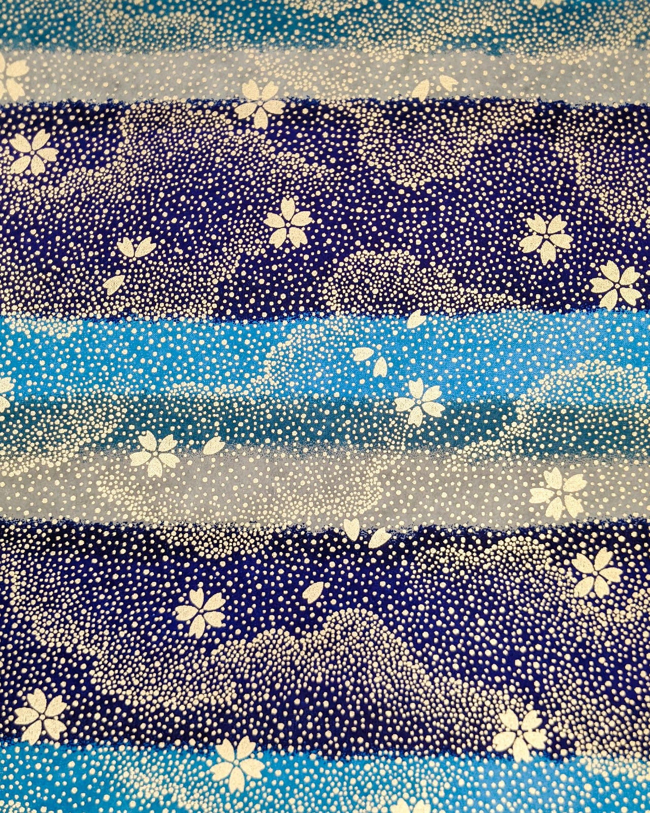 Japanese chiyogami paper featuring gold cherry blossoms on a blue and gray striped background with metallic gold details.