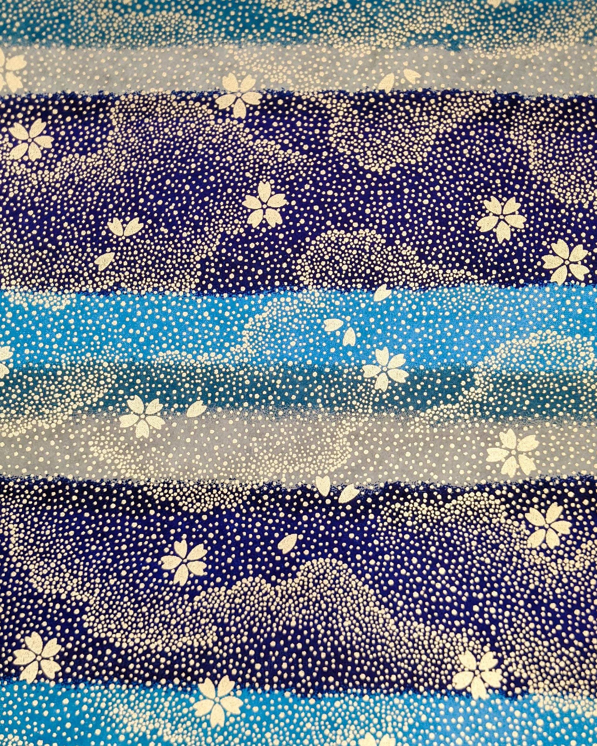 Japanese chiyogami paper featuring gold cherry blossoms on a blue and gray striped background with metallic gold details.