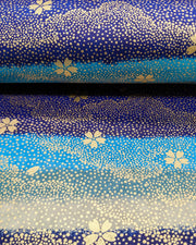 Japanese chiyogami paper featuring gold cherry blossoms on a blue and gray striped background with metallic gold details.
