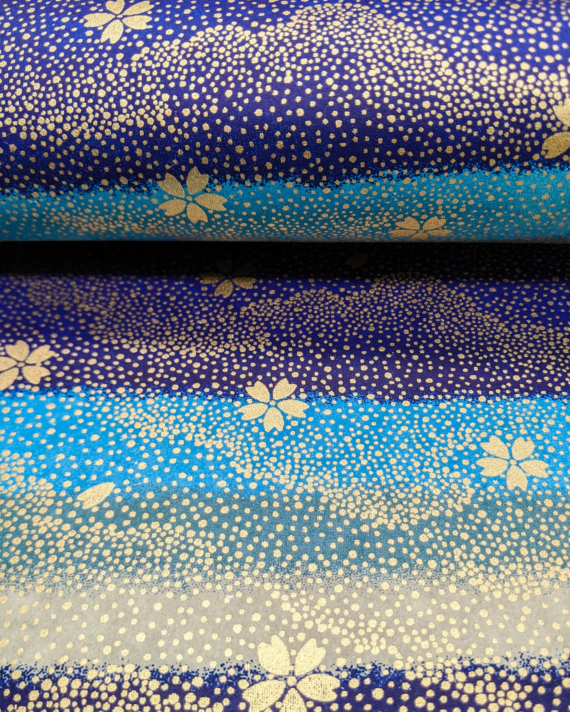 Japanese chiyogami paper featuring gold cherry blossoms on a blue and gray striped background with metallic gold details.