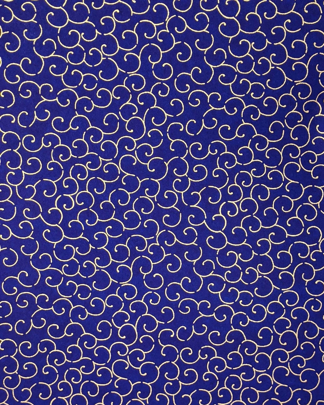 Japanese chiyogami paper featuring a metallic gold traditional karakusa design on a dark blue background.