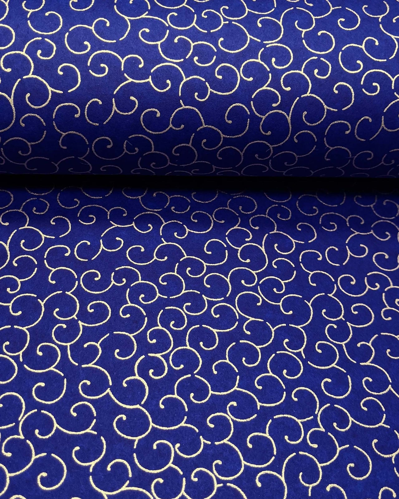 Japanese chiyogami paper featuring a metallic gold traditional karakusa design on a dark blue background.