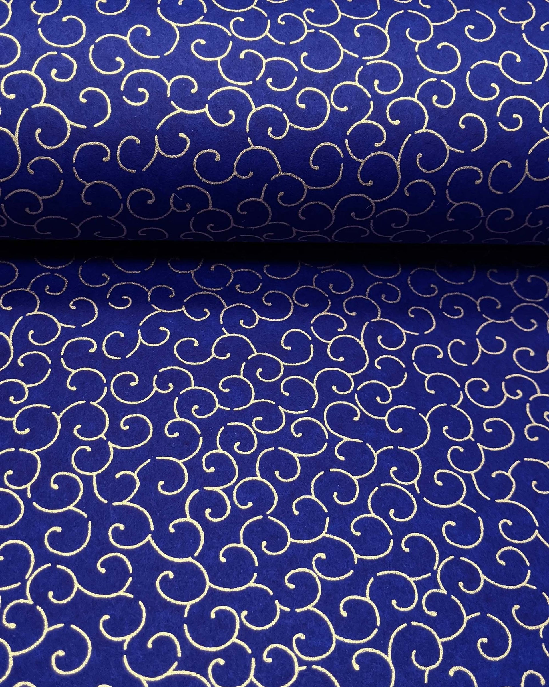 Japanese chiyogami paper featuring a metallic gold traditional karakusa design on a dark blue background.
