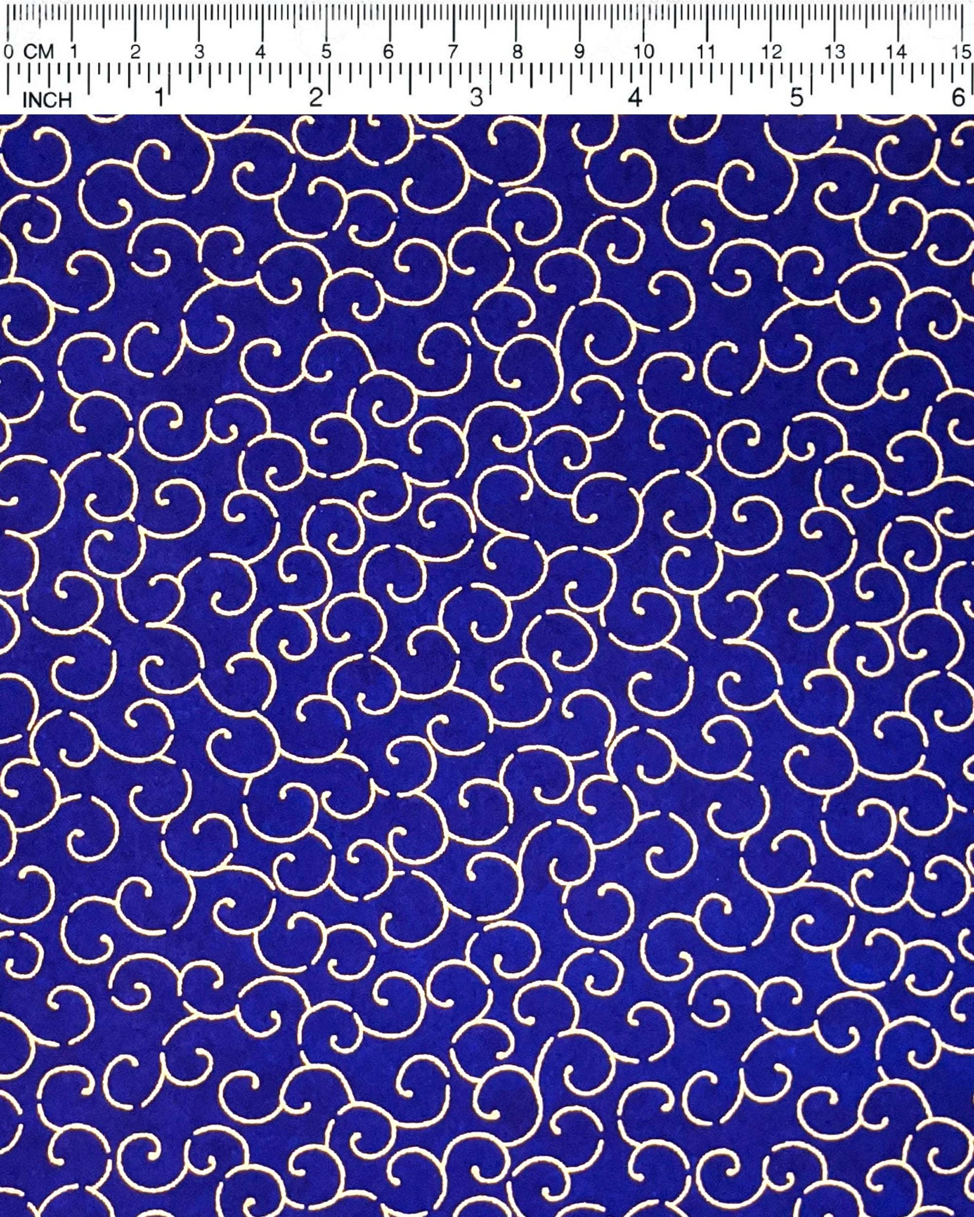 Japanese chiyogami paper featuring a metallic gold traditional karakusa design on a dark blue background.