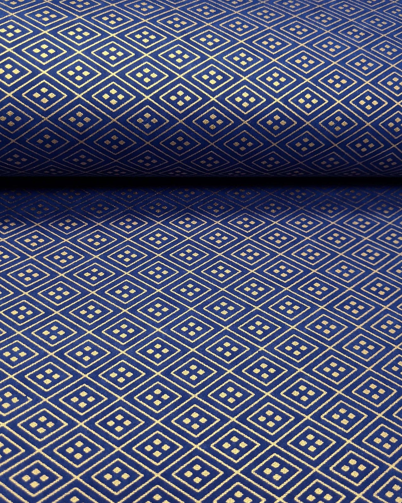 Japanese chiyogami paper featuring a metallic gold traditional hishi design on a dark blue background. 