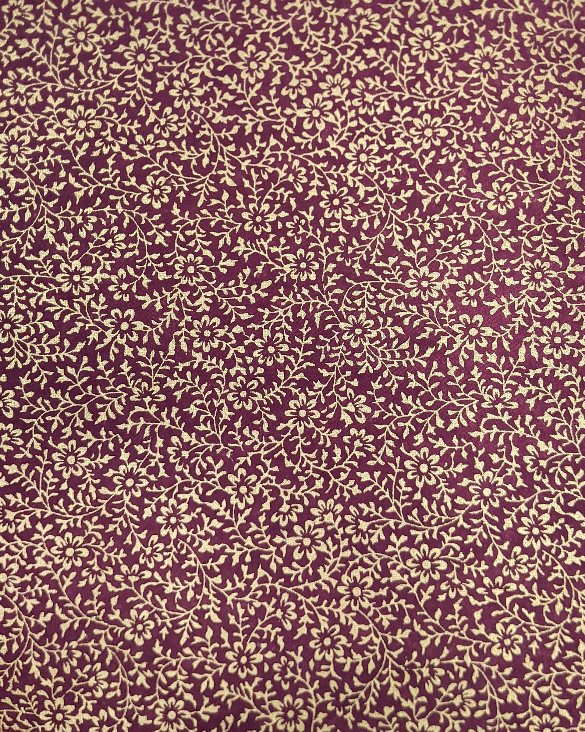 Japanese chiyogami paper featuring a metallic gold floral motif on a purple background.