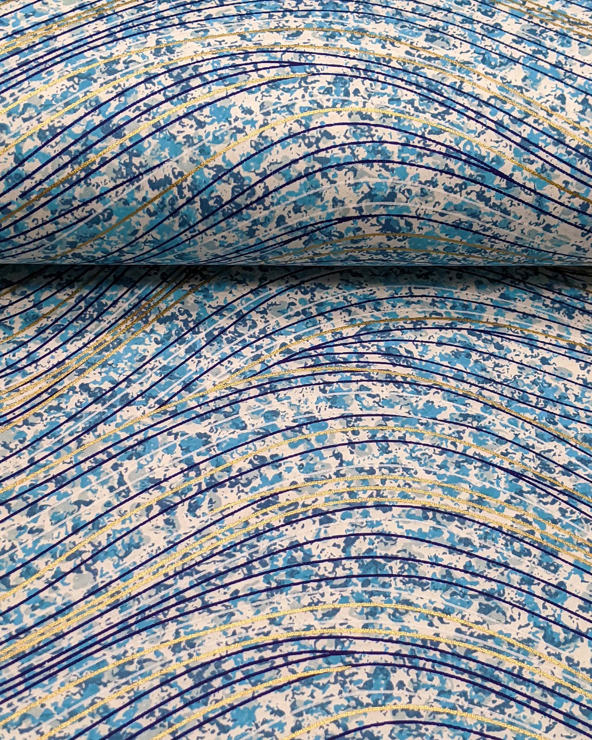 Japanese chiyogami paper featuring metallic gold and dark blue swirls on a light blue and white speckled background.
