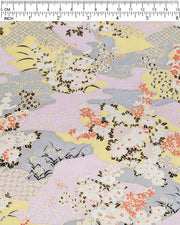 Japanese chiyogami paper featuring small white, black, and orange flowers on a pink, beige, and purple background embedded with various traditional Japanese motifs with metallic gold details.
