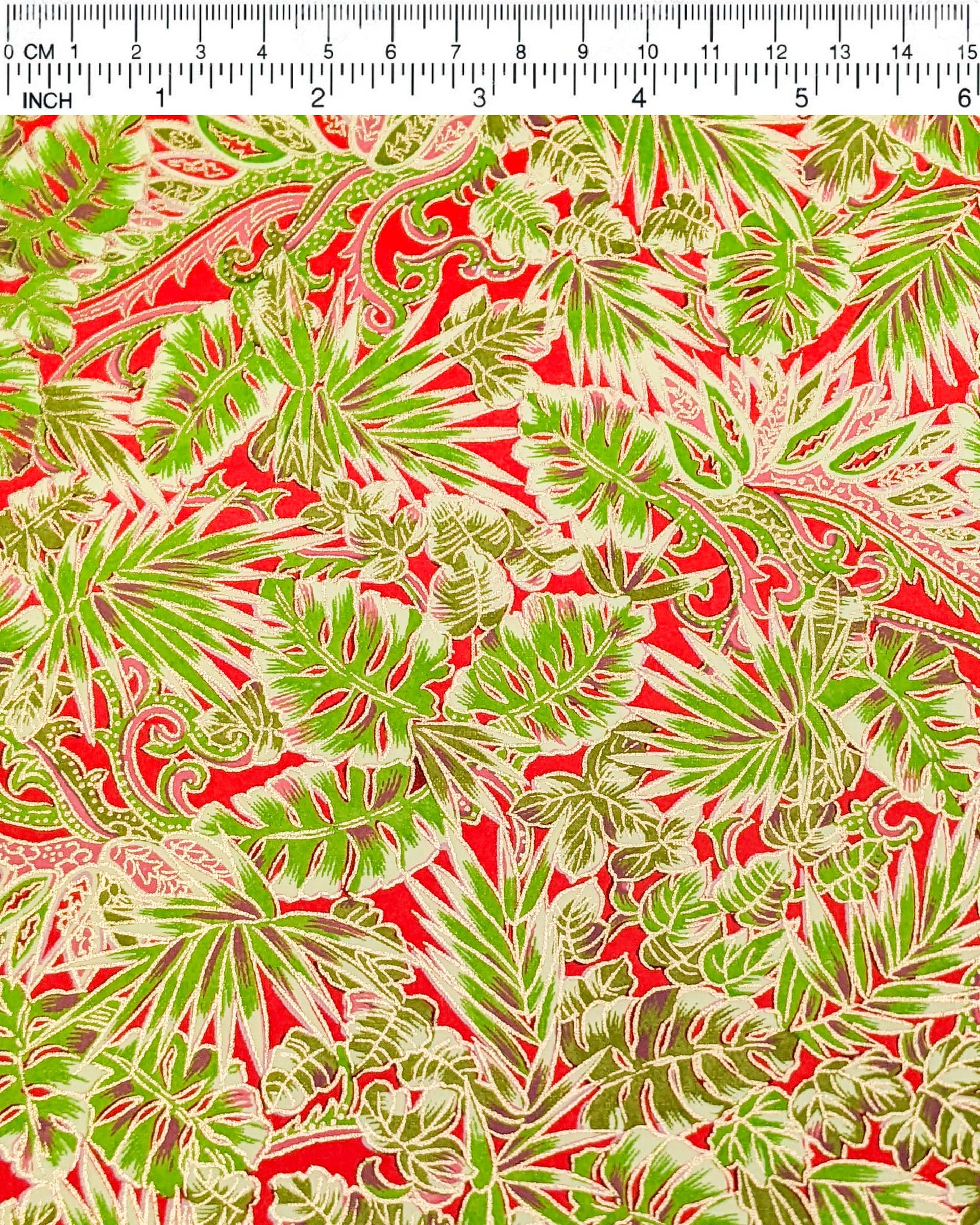 Japanese chiyogami paper featuring green and pink frond leaves on a red background with metallic gold details.