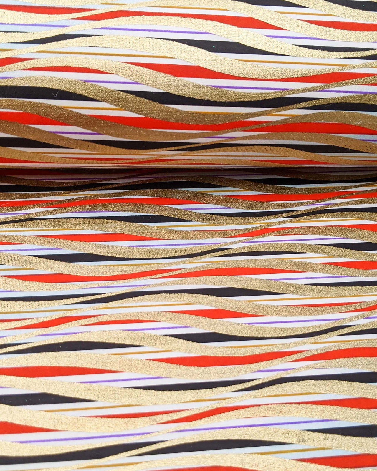 Japanese chiyogami paper featuring metallic gold swirls o a red, white, and black striped background.