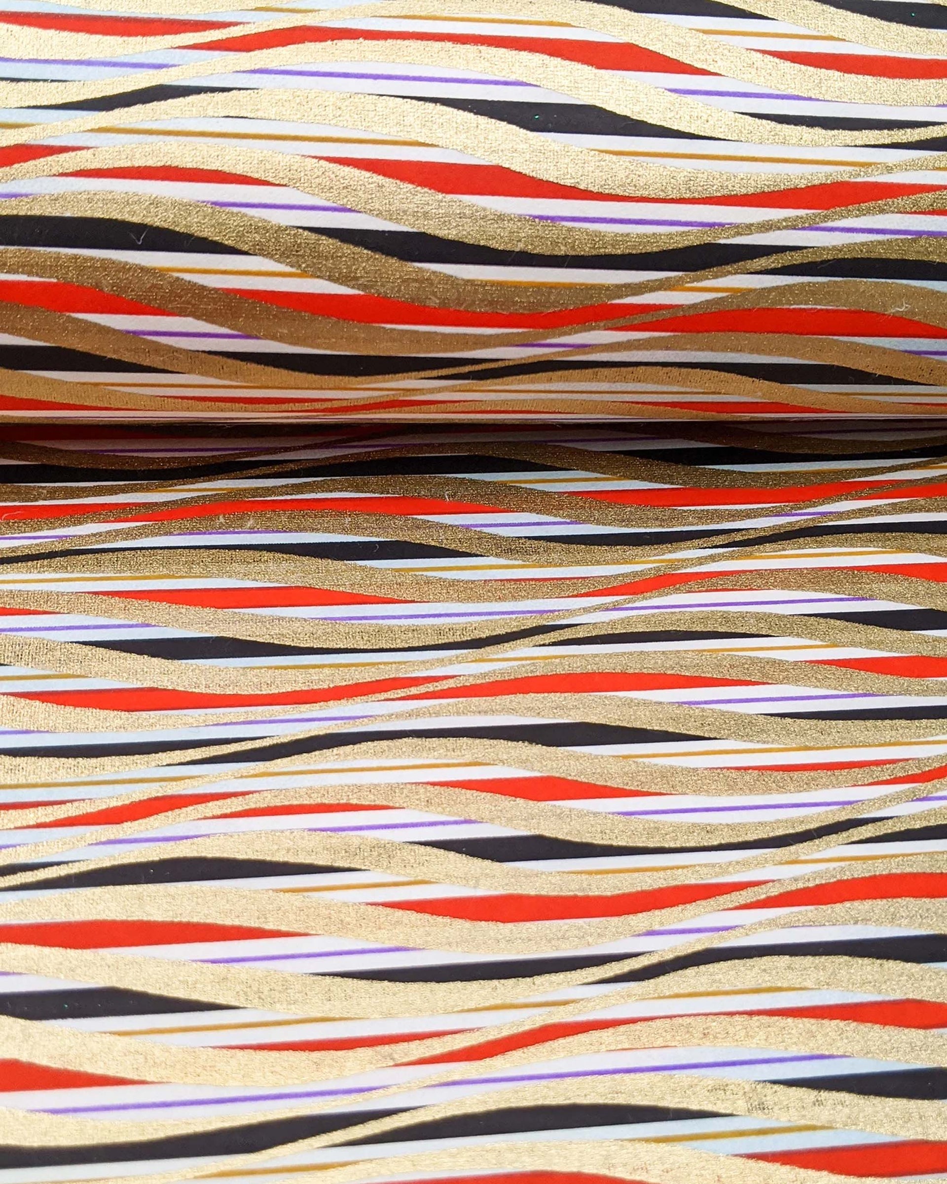 Japanese chiyogami paper featuring metallic gold swirls o a red, white, and black striped background.