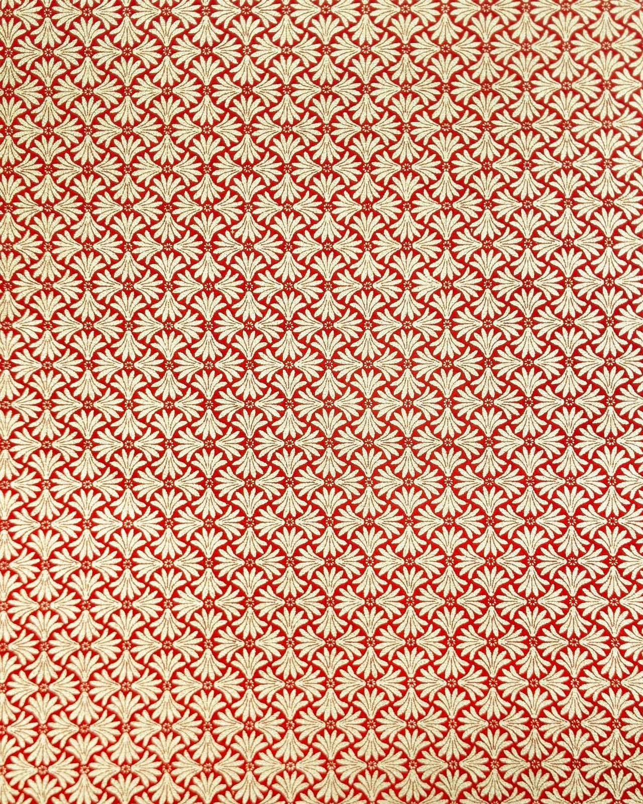 Japanese chiyogami paper featuring metallic gold geometric stylized flowers on a red background.