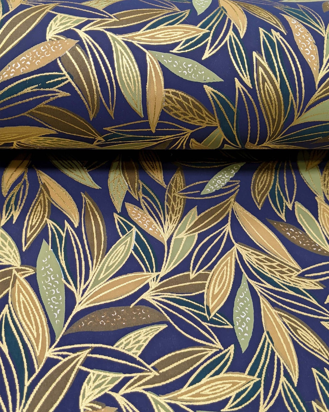 Japanese chiyogami paper featuring thin brown and green leaves on a dark blue (almost black) background with metallic gold details.