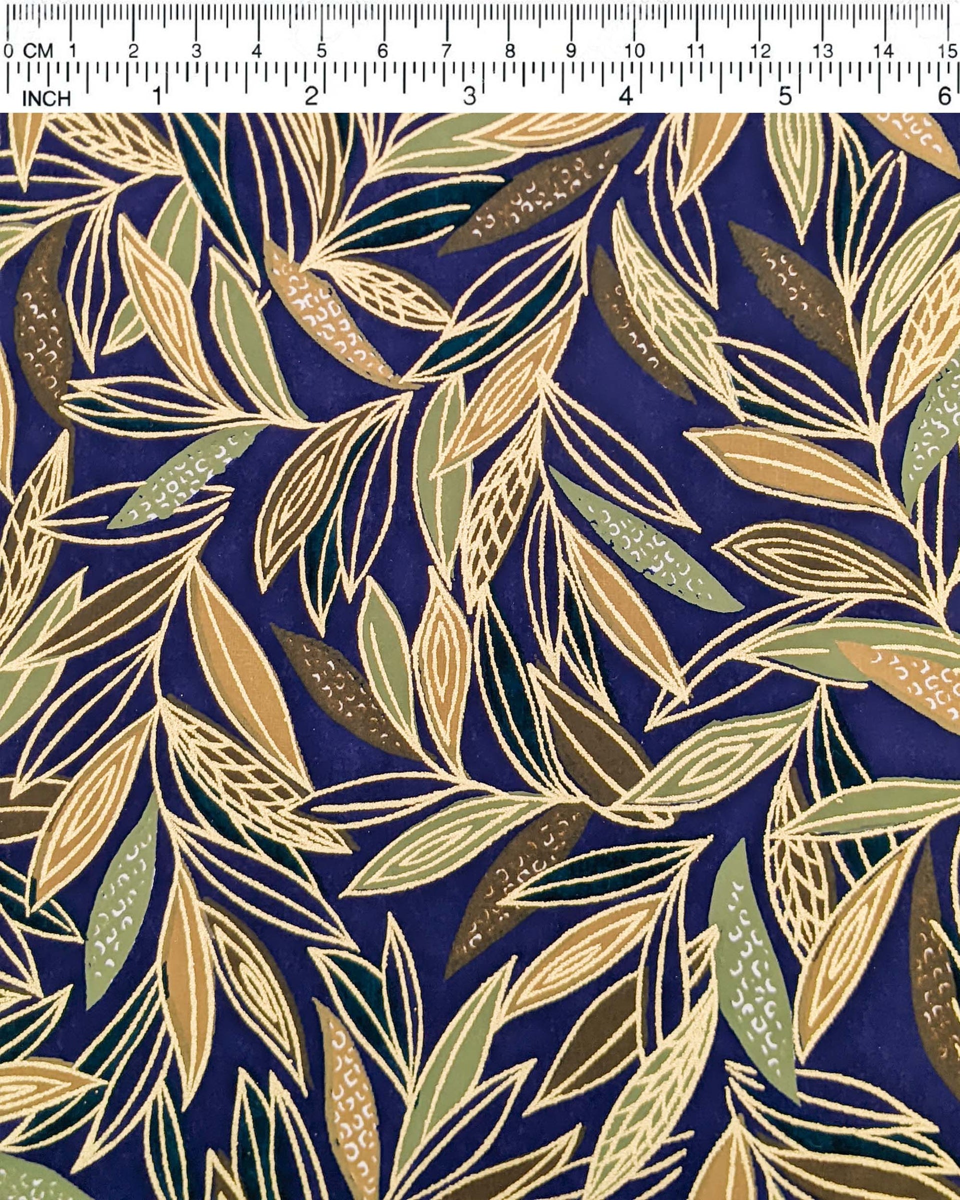 Japanese chiyogami paper featuring thin brown and green leaves on a dark blue (almost black) background with metallic gold details.