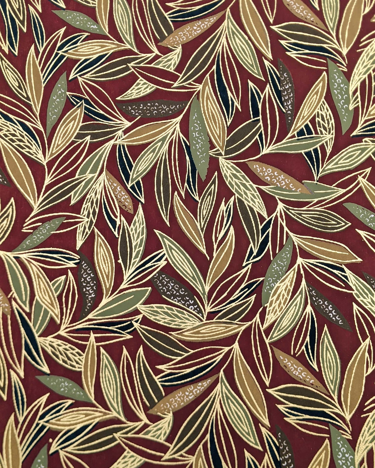 Japanese chiyogami paper featuring thin brown and green leaves on a brown background with metallic gold details.