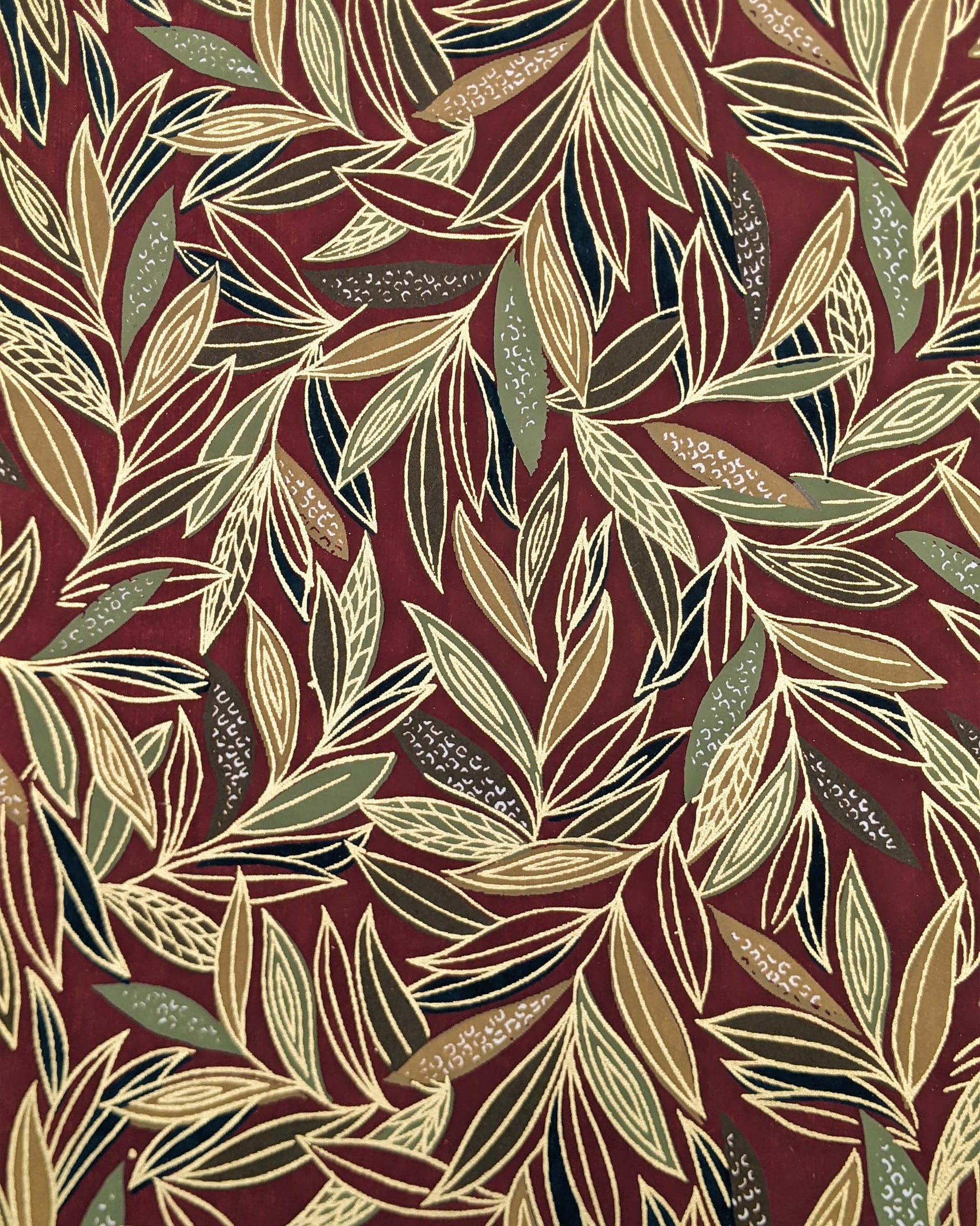 Japanese chiyogami paper featuring thin brown and green leaves on a brown background with metallic gold details.