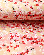 Japanese chiyogami paper featuring pink, red, and white cherry blossoms on a pink and beige background with metallic gold details.