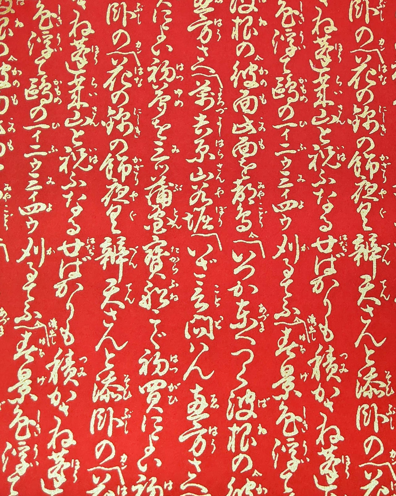 Japanese chiyogami paper featuring vertical metallic gold calligraphy on a red background.