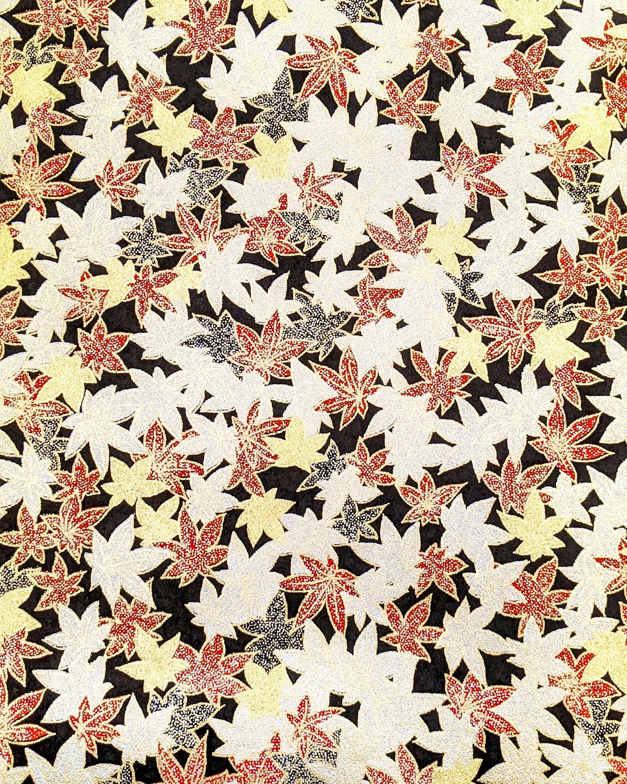 Japanese chiyogami paper featuring red, black, gold, and silver maples leaves on a black background with metallic gold details.