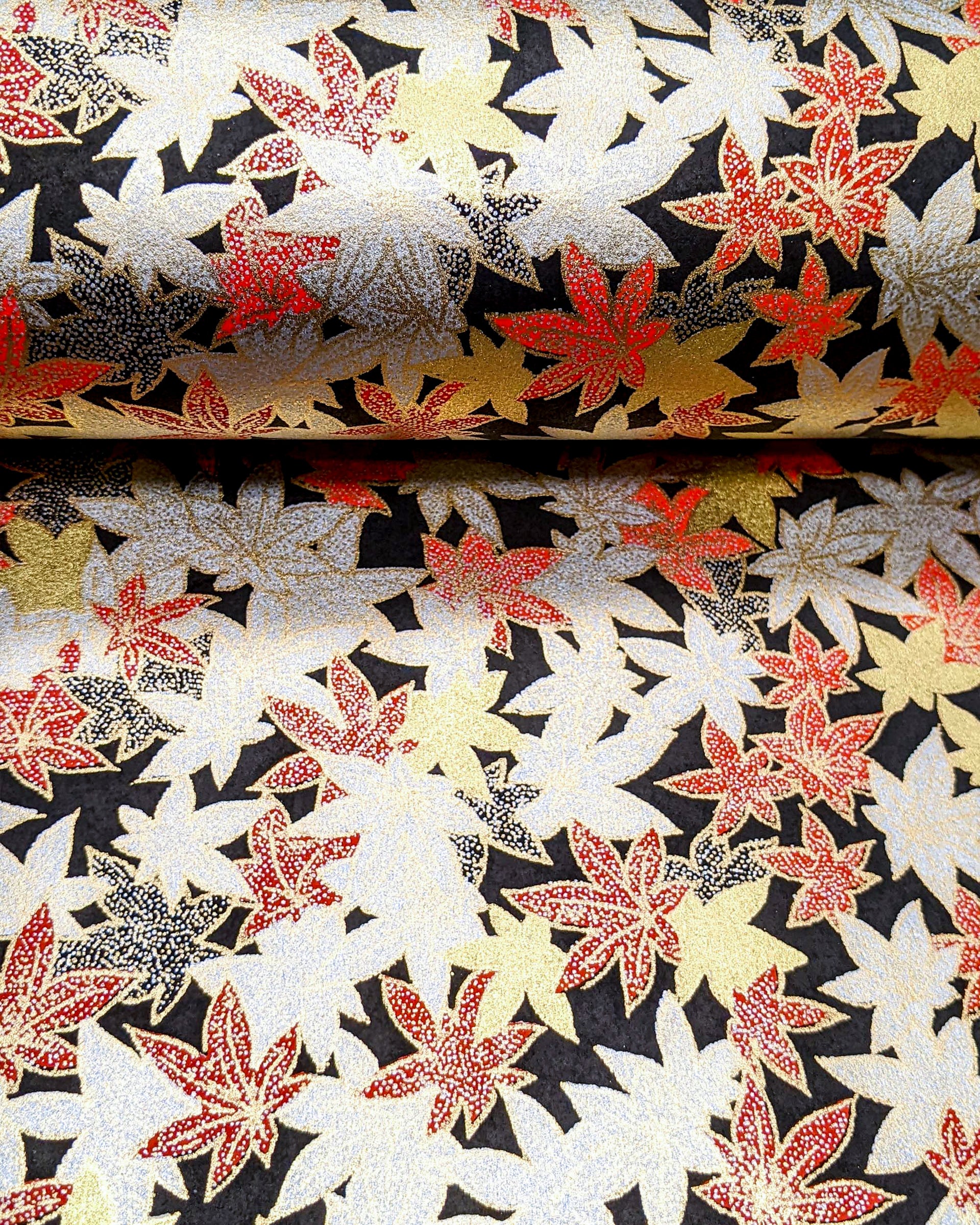 Japanese chiyogami paper featuring red, black, gold, and silver maples leaves on a black background with metallic gold details.
