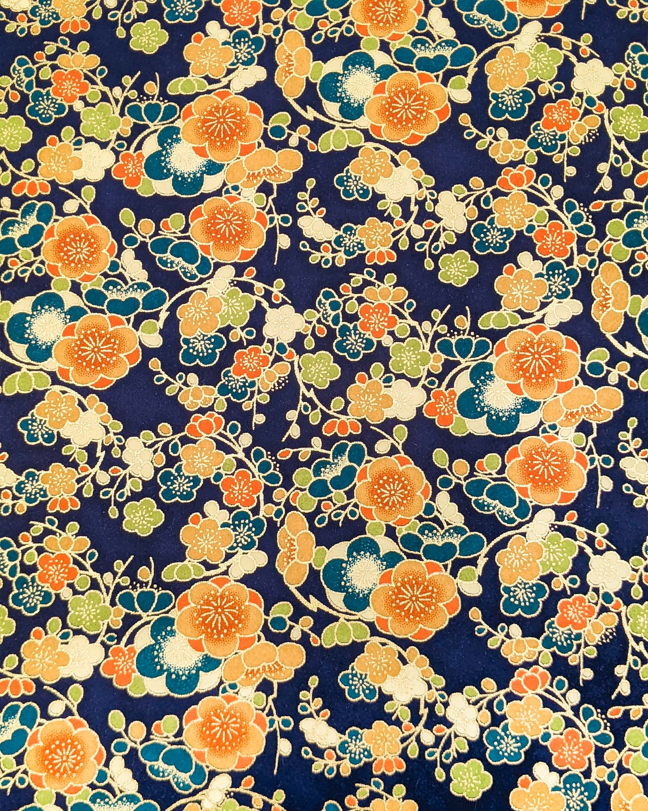 Japanese chiyogami paper featuring orange, blue, green, and cream plum blossoms on a dark blue background with metallic gold details.