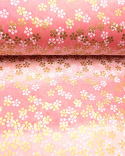 Japanese chiyogami paper featuring metallic gold and white round blossoms on a pink gradient background.