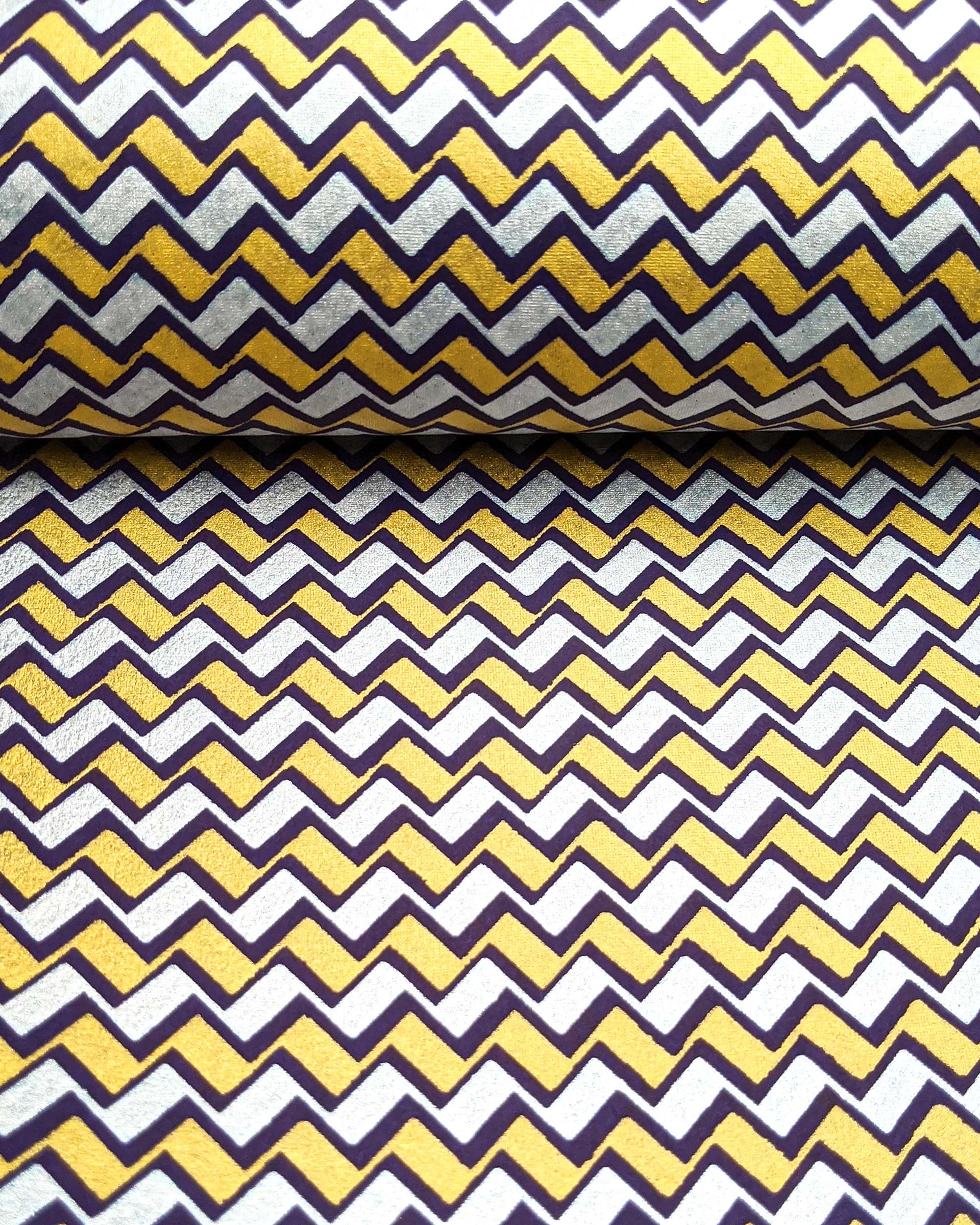 Japanese chiyogami paper featuring a navy blue, metallic silver, and metallic gold zigzag chevron pattern.