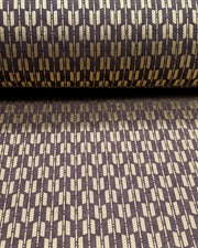Japanese chiyogami paper featuring a traditional metallic gold yagasuri (arrow fletching) pattern on a gray background, shown rolled to highlight the design.