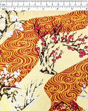 Japanese chiyogami paper featuring pink and white plum and cherry blossom trees set against a metallic gold and red water ripple pattern on a gold background, shown next to a ruler for size reference.