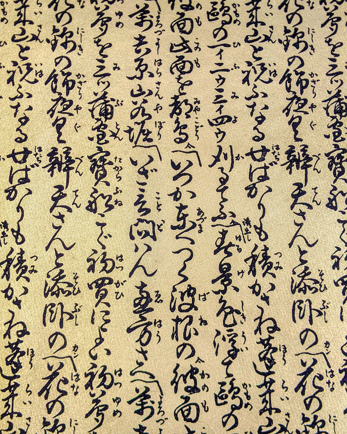 Japanese chiyogami paper featuring black Japanese calligraphy on a metallic gold background.