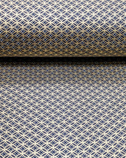 Japanese chiyogami paper featuring a traditional oval shippo pattern in metallic gold with four white dots in the center on a black background, shown rolled to highlight the design.