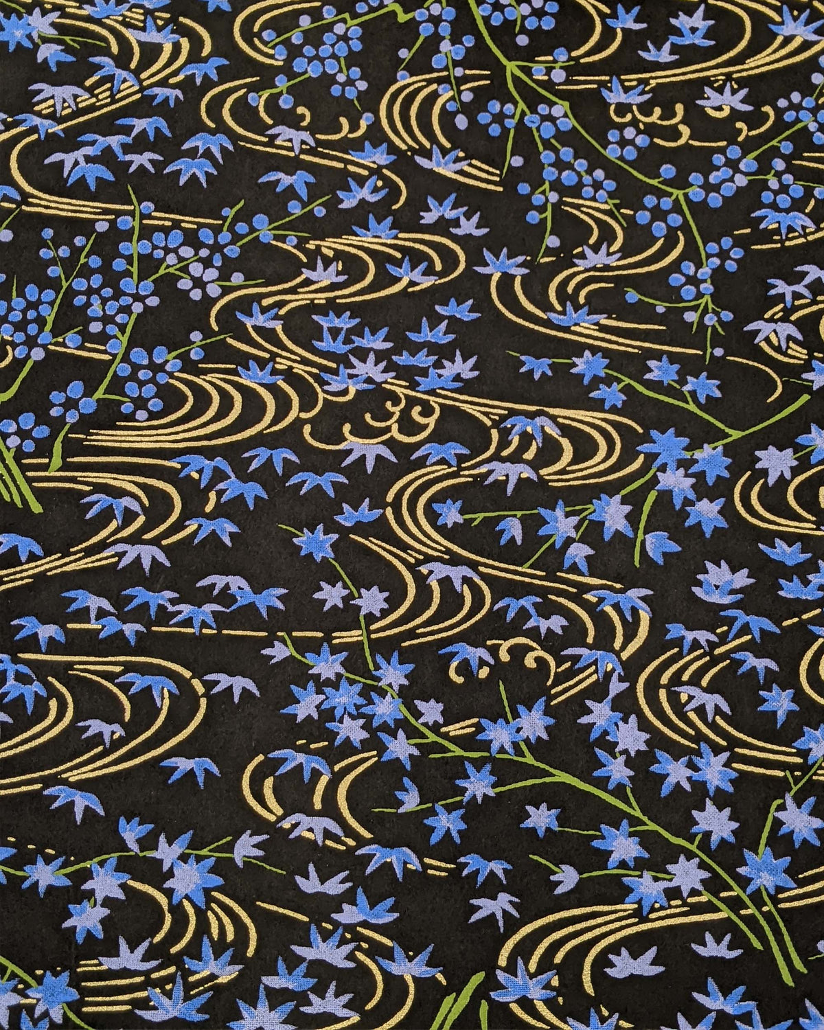 Japanese chiyogami paper featuring small blue maples leaves with green branches over flowing metallic gold streams on a black background.