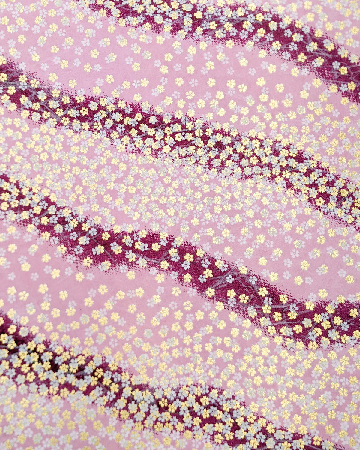 Japanese chiyogami paper featuring small white and metallic gold cherry blossoms on a gradient purple background.