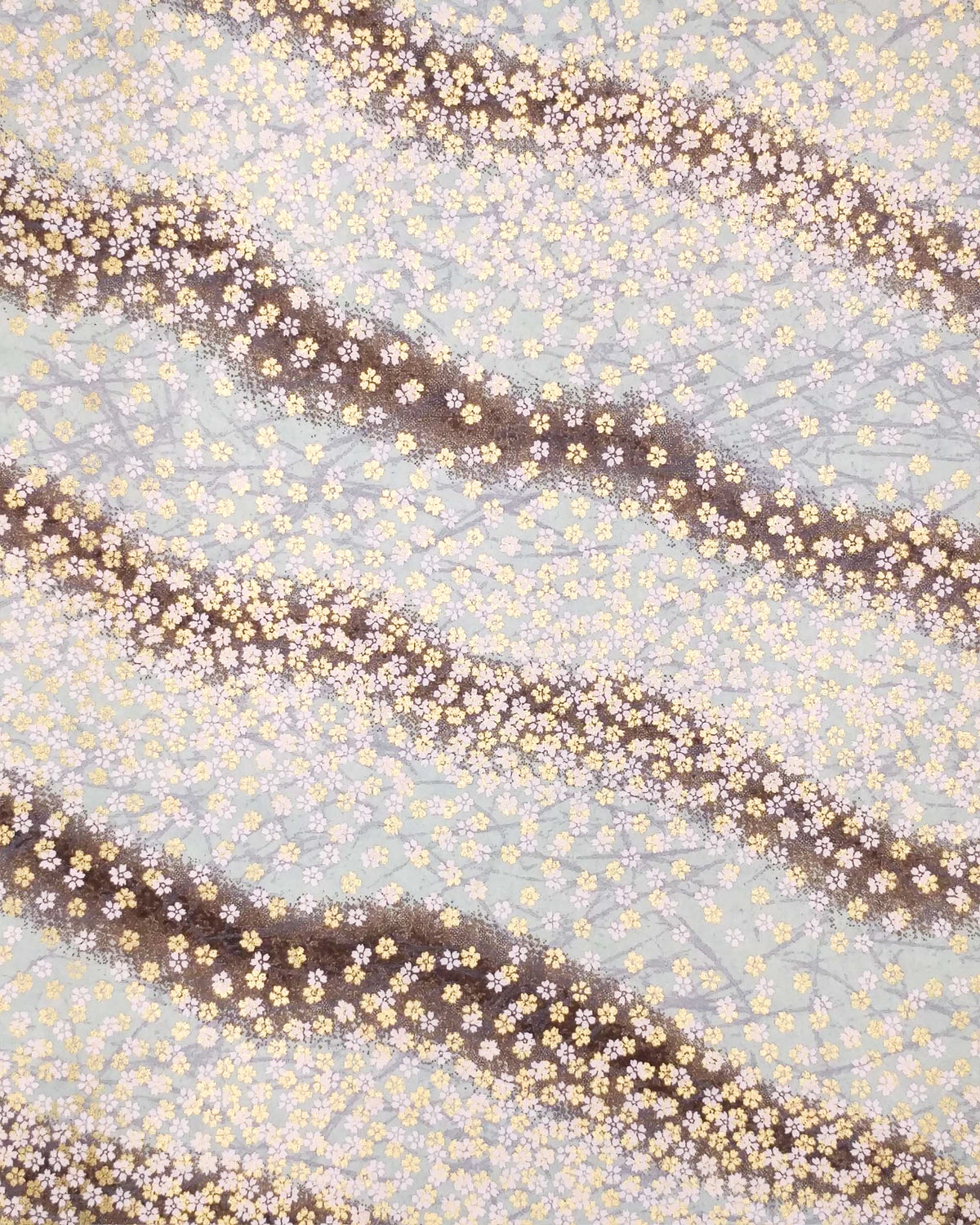 Japanese chiyogami paper featuring small white and metallic gold cherry blossoms on a gradient blue gray background.
