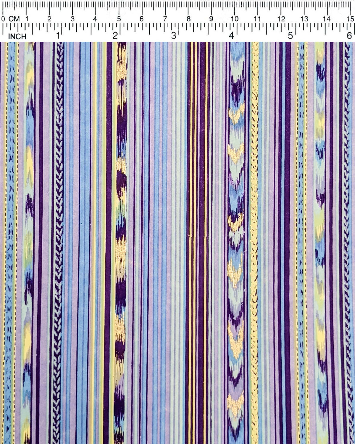 Japanese chiyogami paper featuring assorted solid and patterned vertical stripes in shades of purple, light blue, and yellow with metallic gold detail, shown next to a ruler for size reference.
