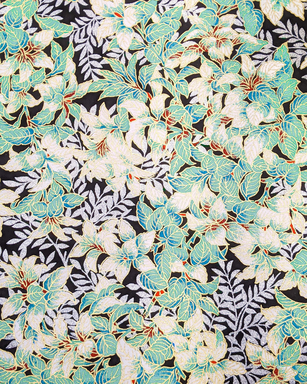 Japanese chiyogami paper featuring green and white leaves with metallic silver leaves on a black background with metallic gold details.