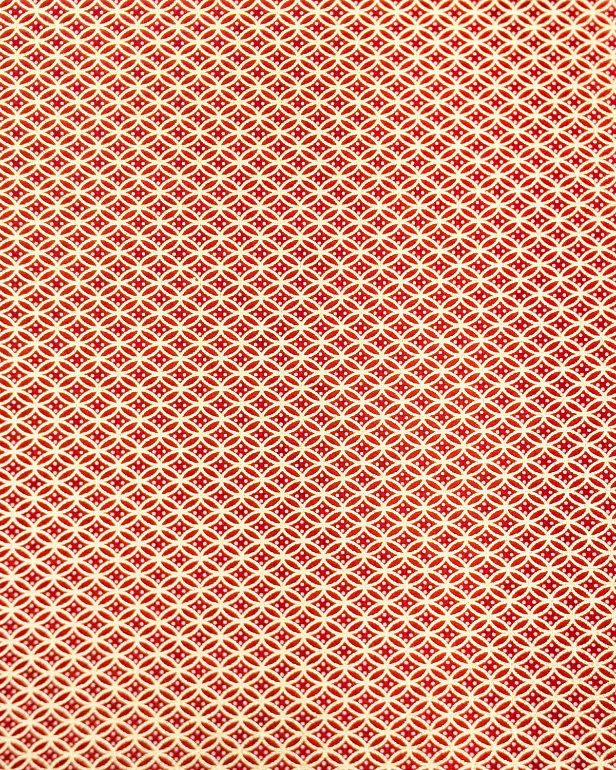This design features a traditional oval shippo pattern in metallic gold with four white dots in the center on a red background.