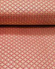Japanese chiyogami paper featuring a traditional oval shippo pattern in metallic gold with four white dots in the center on a red background, shown rolled to highlight the design.