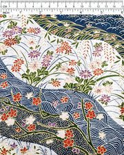 Japanese chiyogami paper featuring red, purple, pink, and white chrysanthemums, plum blossoms, wisteria, and other flowers arranged among traditional Japanese patterns on a blue and silver background with metallic gold details, shown next to a ruler for size reference.